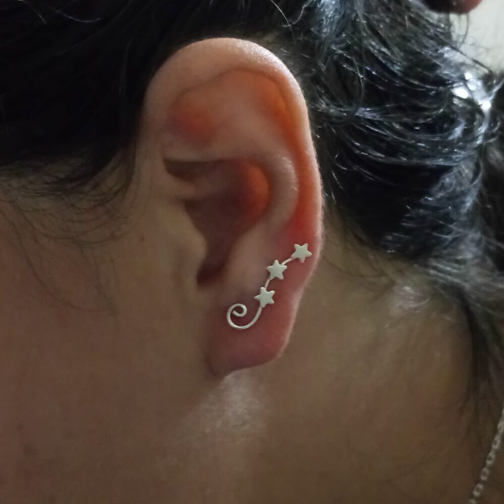 Brincos Fio de Luz em prata 925 com estrelas e traço curvo — um símbolo de direção, leveza e luz no próprio caminho.